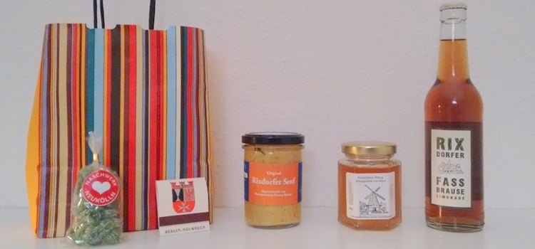 Geschenktüte und verschiedene Lebensmittel aus Neukölln (Senf, Honig, Brause, Bonbons)